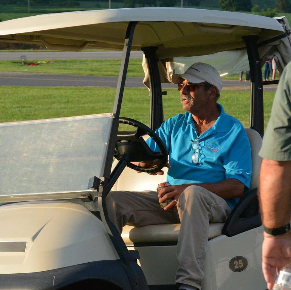 Dave Garris, manager of Johnson County Airport, driving a cart on the airfield