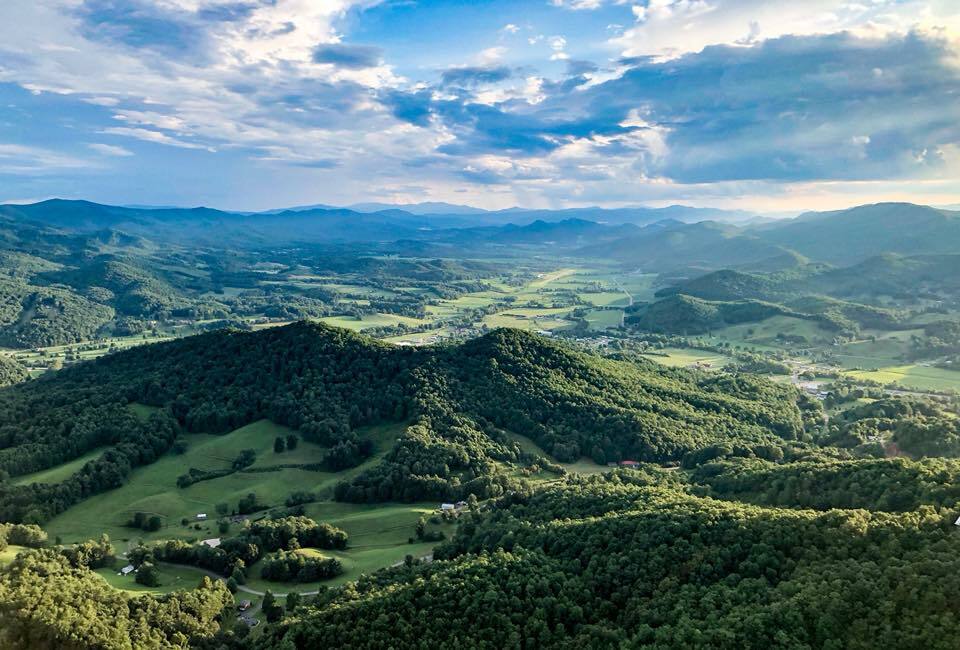 Rolling green mountains and valley farmland seen from the air near Mountain City
